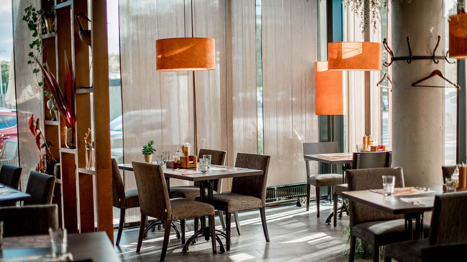 The empty dining room of a new restaurant before it opens, tables set and chairs pushed in for the first guests.